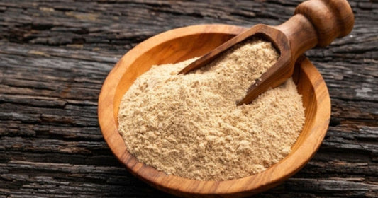 Fine kava powder in a wooden bowl with a scoop, used for instant kava preparation